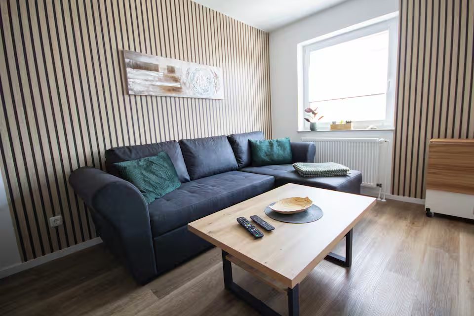 Wohnzimmer mit Holzlamellen und Sofa